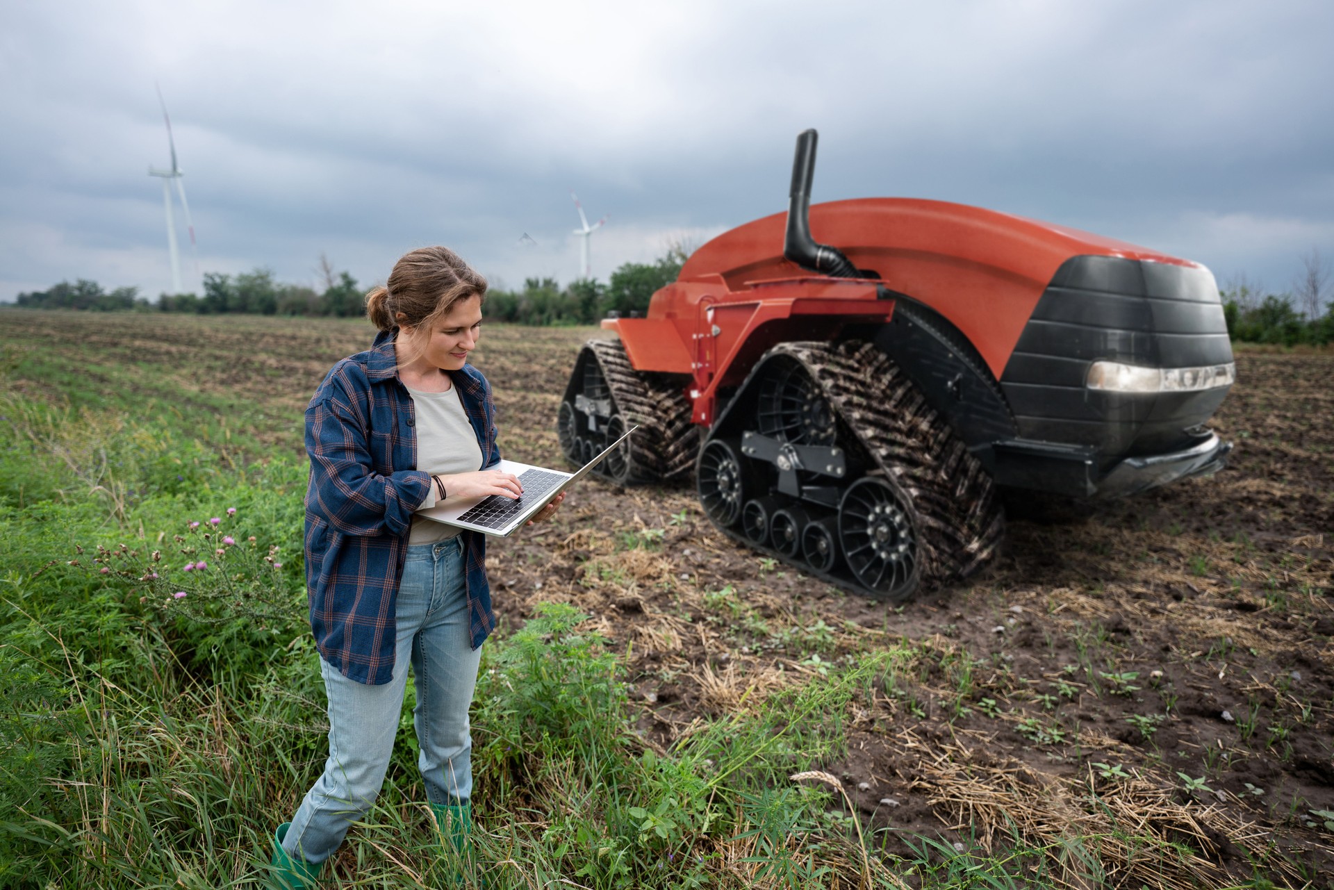 Farmer with digital tablet controls an autonomous tractor